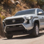 Silver Toyota Tacoma SR5 driving on a desert dirt road