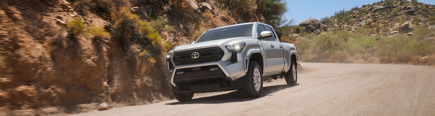 Silver Toyota Tacoma SR5 driving on a desert dirt road