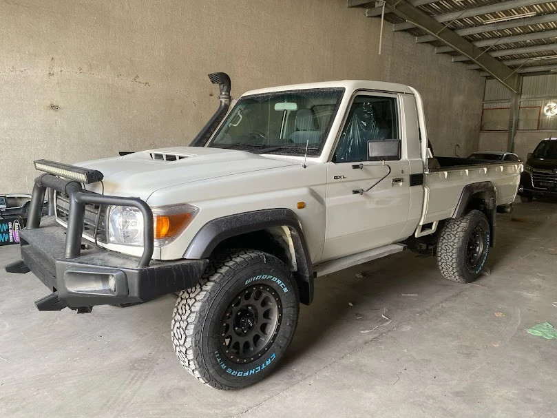 alt text: A white 2017 Toyota Land Cruiser single-cab pickup truck in profile view.