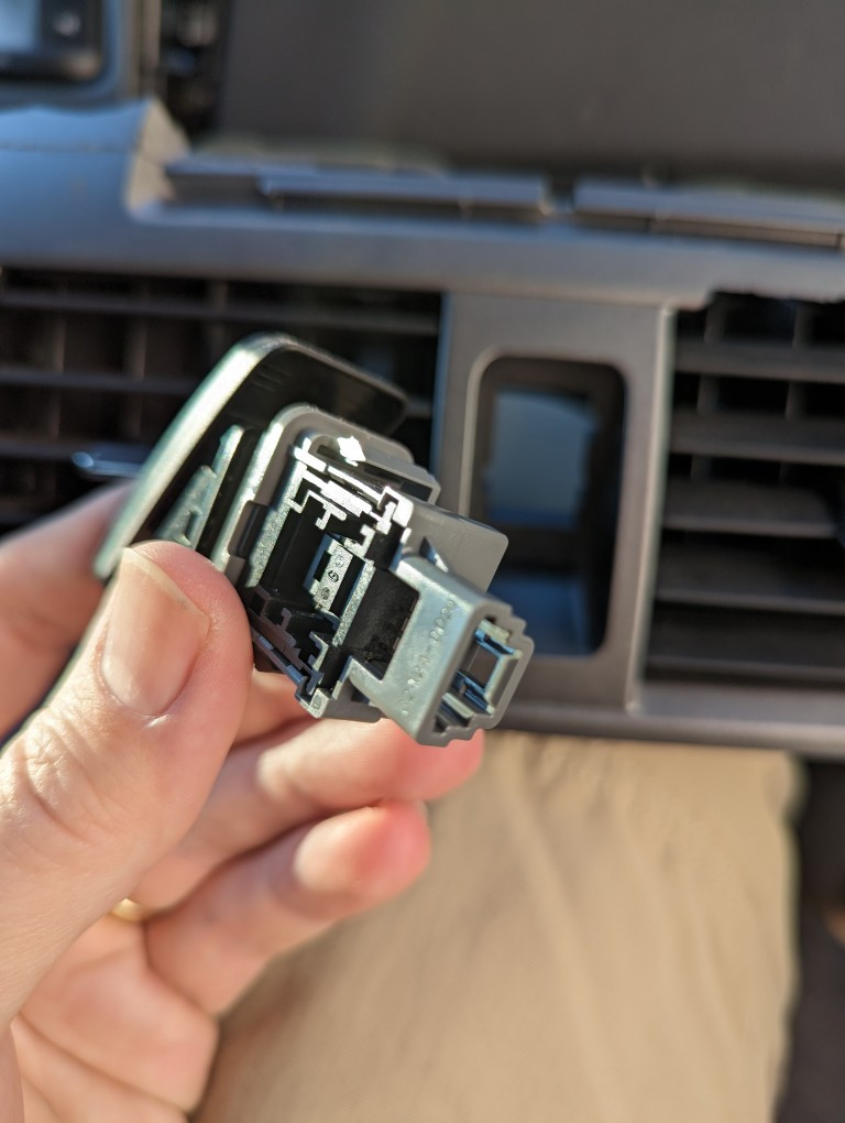 Close up of the caution lights switch from a 2013 Toyota Corolla center console.