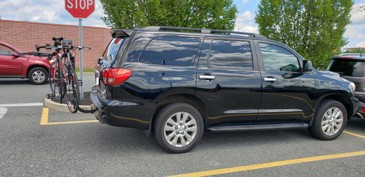 Installation of a hitch-mounted bike rack on a Toyota Sequoia, preparing for family cycling excursions.