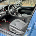 Sport SofTex-trimmed front seats of the 2022 Toyota Camry TRD with red accents and TRD logo on the headrest.