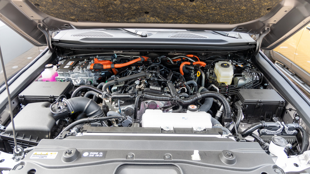 Engine bay of the 2024 Land Cruiser, showcasing the turbocharged 4-cylinder hybrid engine, emphasizing fuel efficiency and adequate power for various driving conditions.