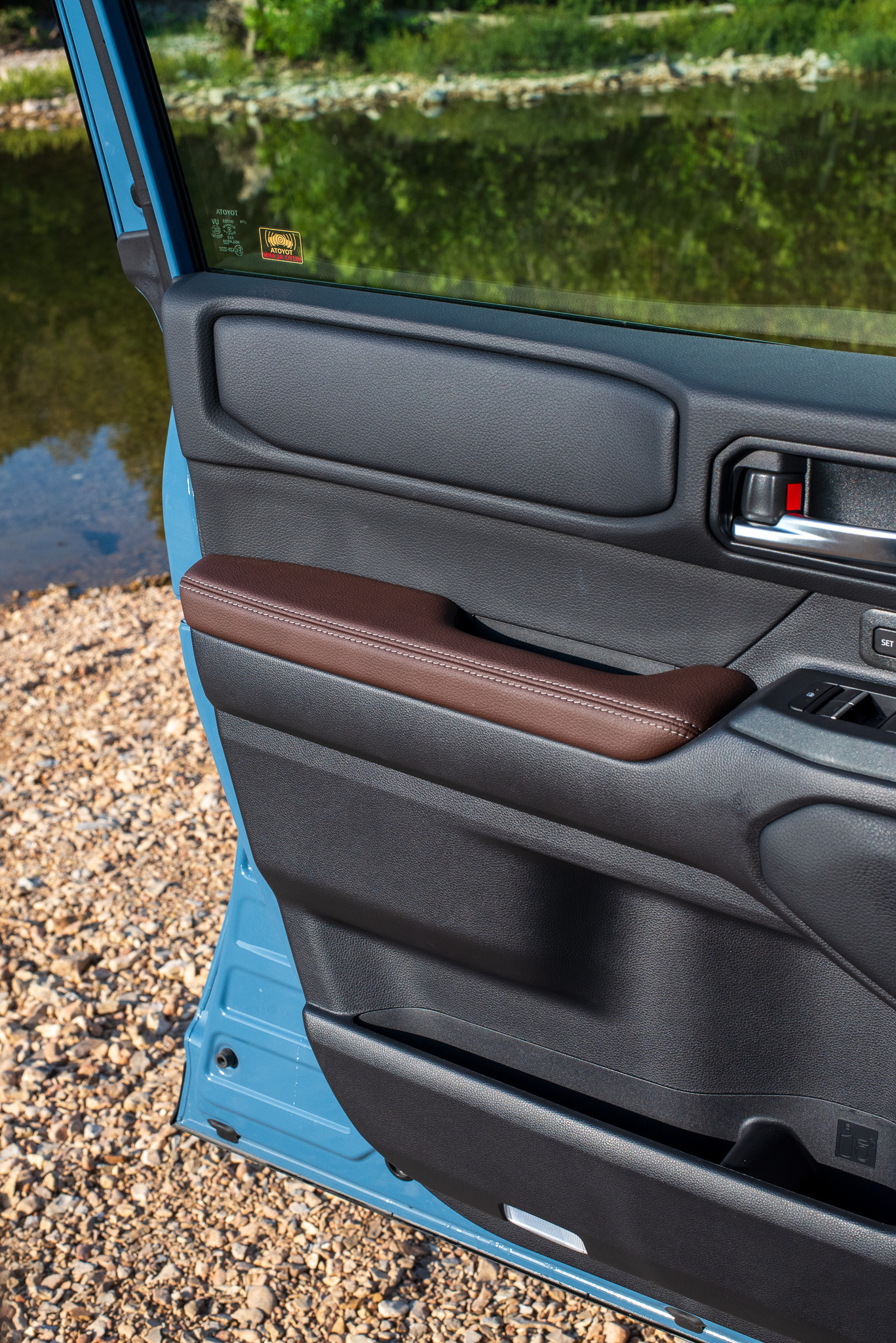 Side interior view of the 2024 Toyota Land Cruiser showing the door panel and seat design.