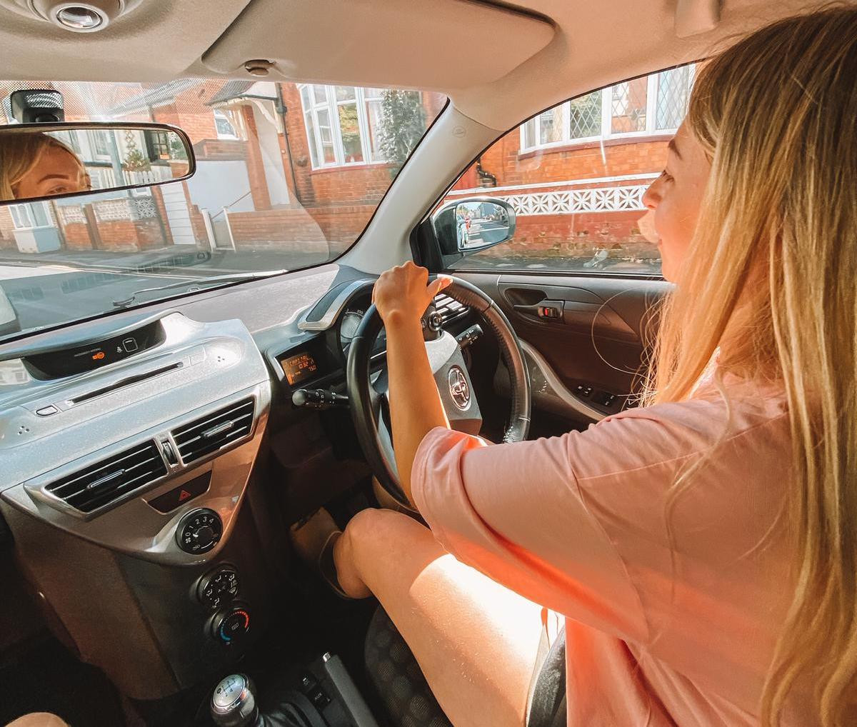 A person sitting comfortably in the back of a Toyota iQ