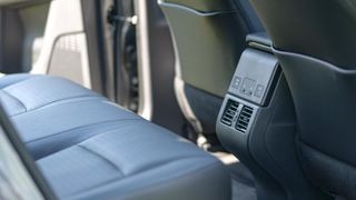 Spacious rear seats and climate controls in the Toyota bZ4X electric SUV.