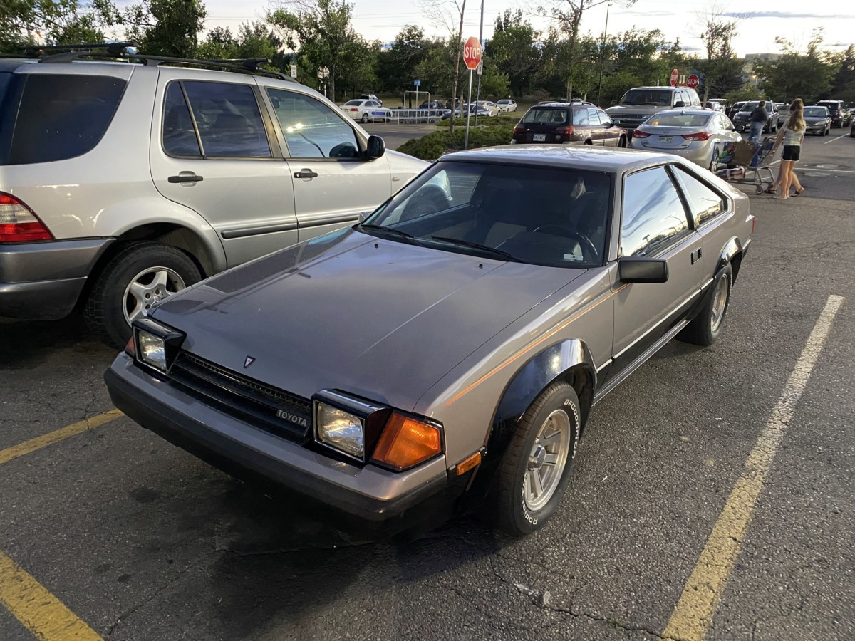 Interior view of a 1985 Toyota Celica GT-S showing the steering wheel, dashboard, and supportive bucket seats.