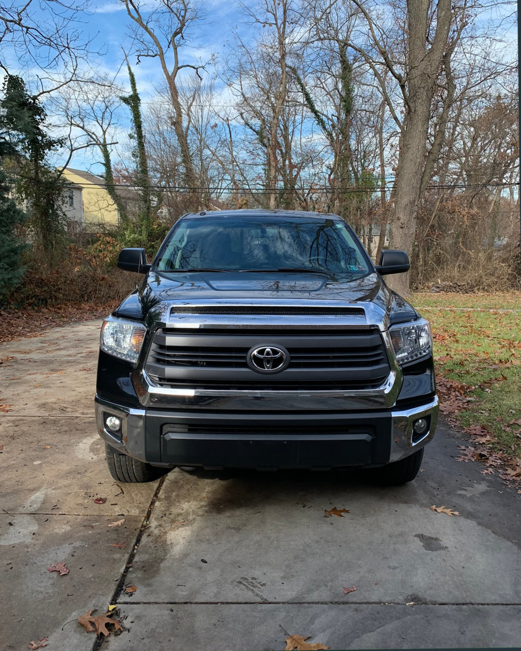 A before-and-after comparison of the front grille of a Toyota Tundra, showing the original chrome grille alongside the new black TRD Pro grille.