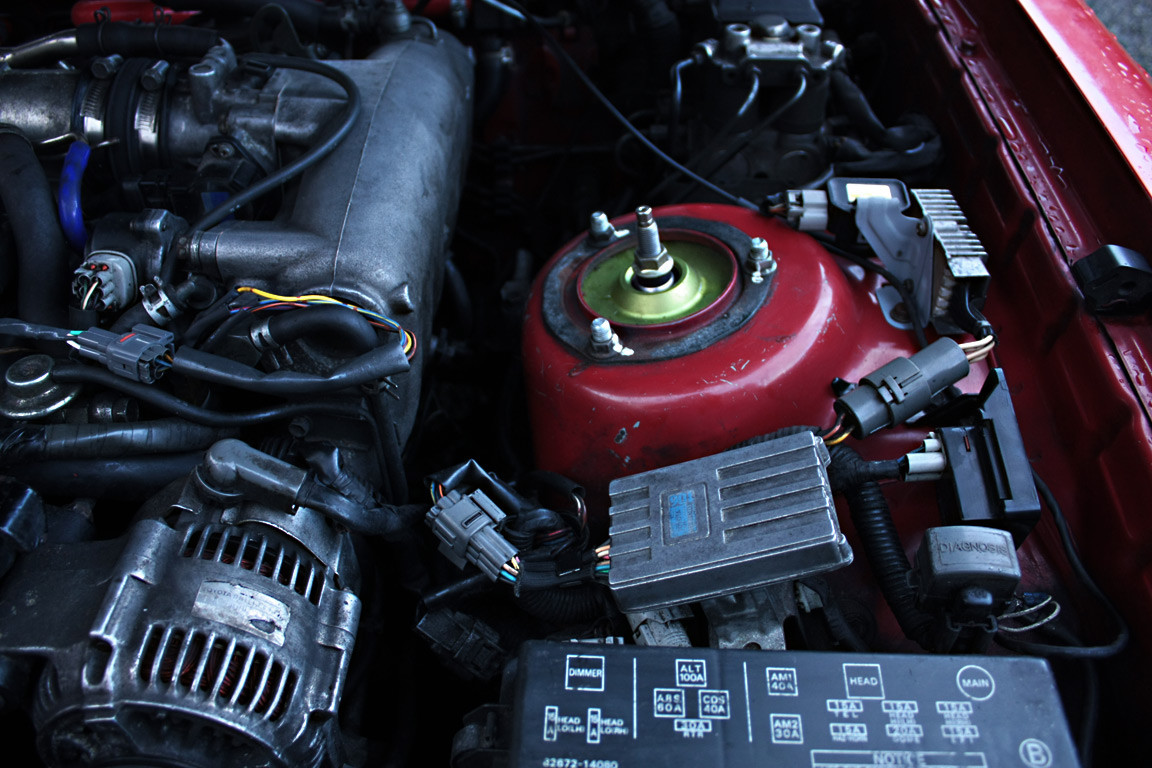 Closeup of cleaned wiring and brackets in a 1990 Toyota Supra engine bay