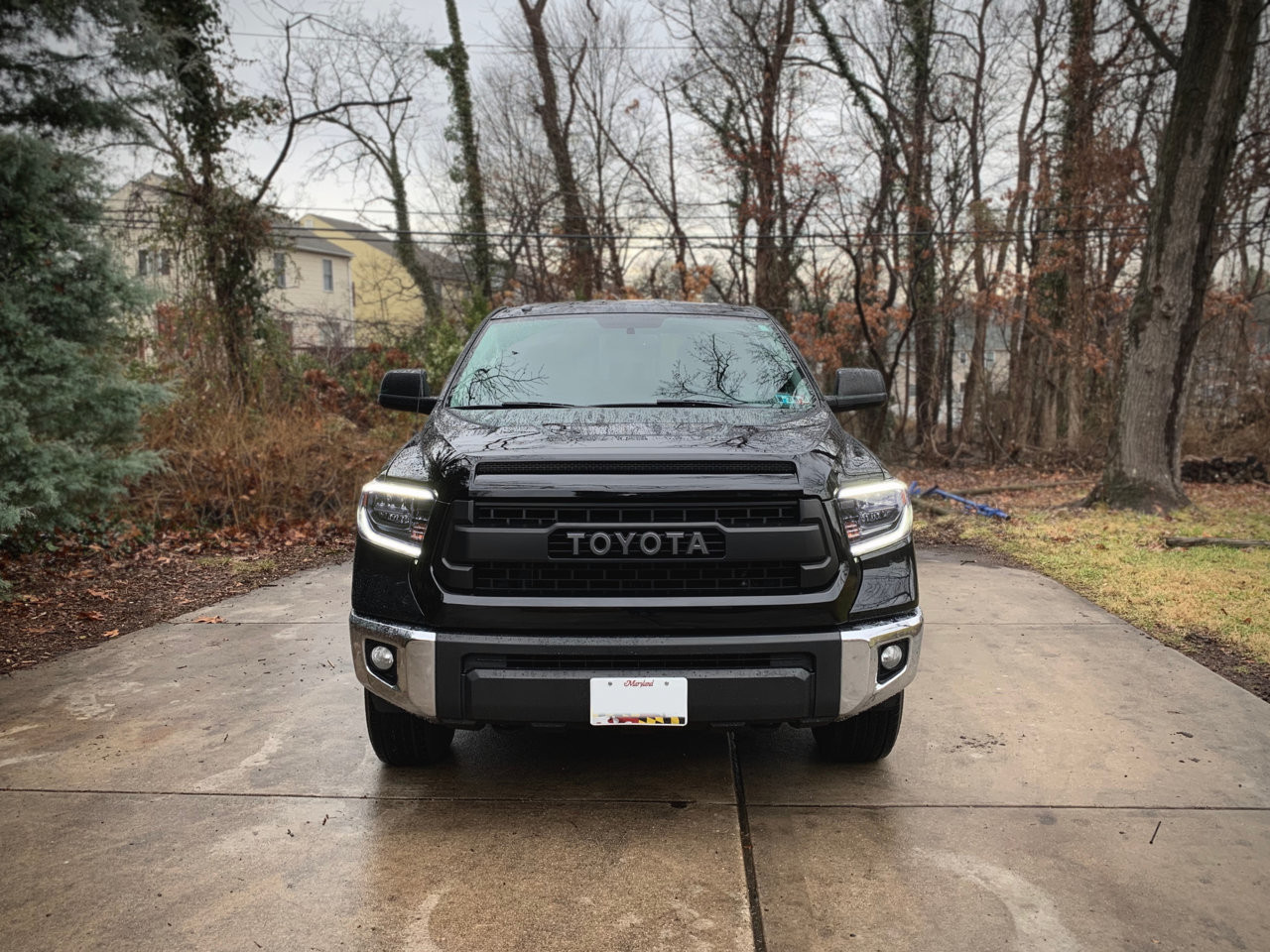 The front of the black Toyota Tundra showcasing its new LED headlights, TRD Pro Grille, and aftermarket front bumper.