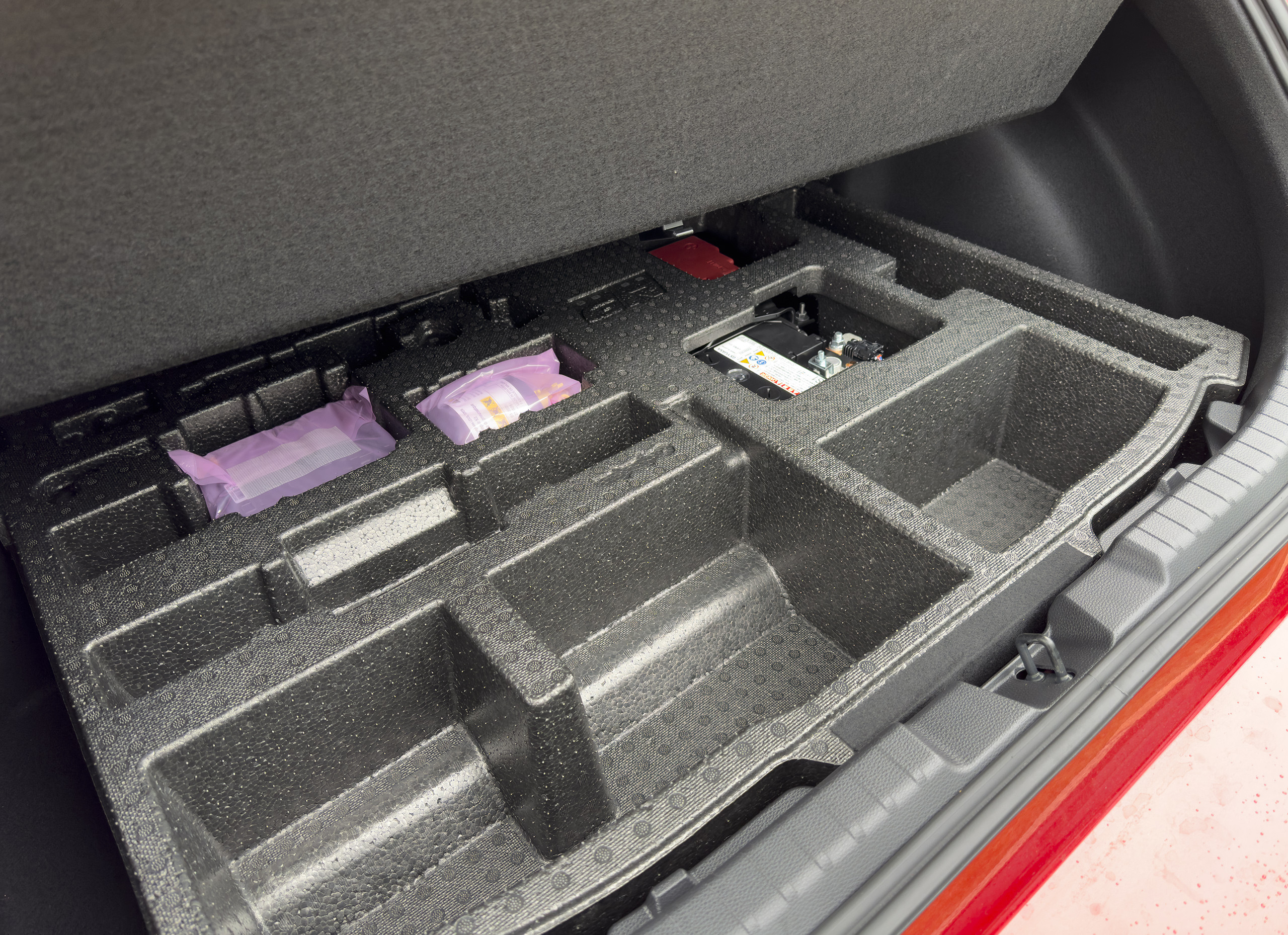 alt text: Close up of the foam cubbies and Fix-a-Flat in the GR Corolla's trunk