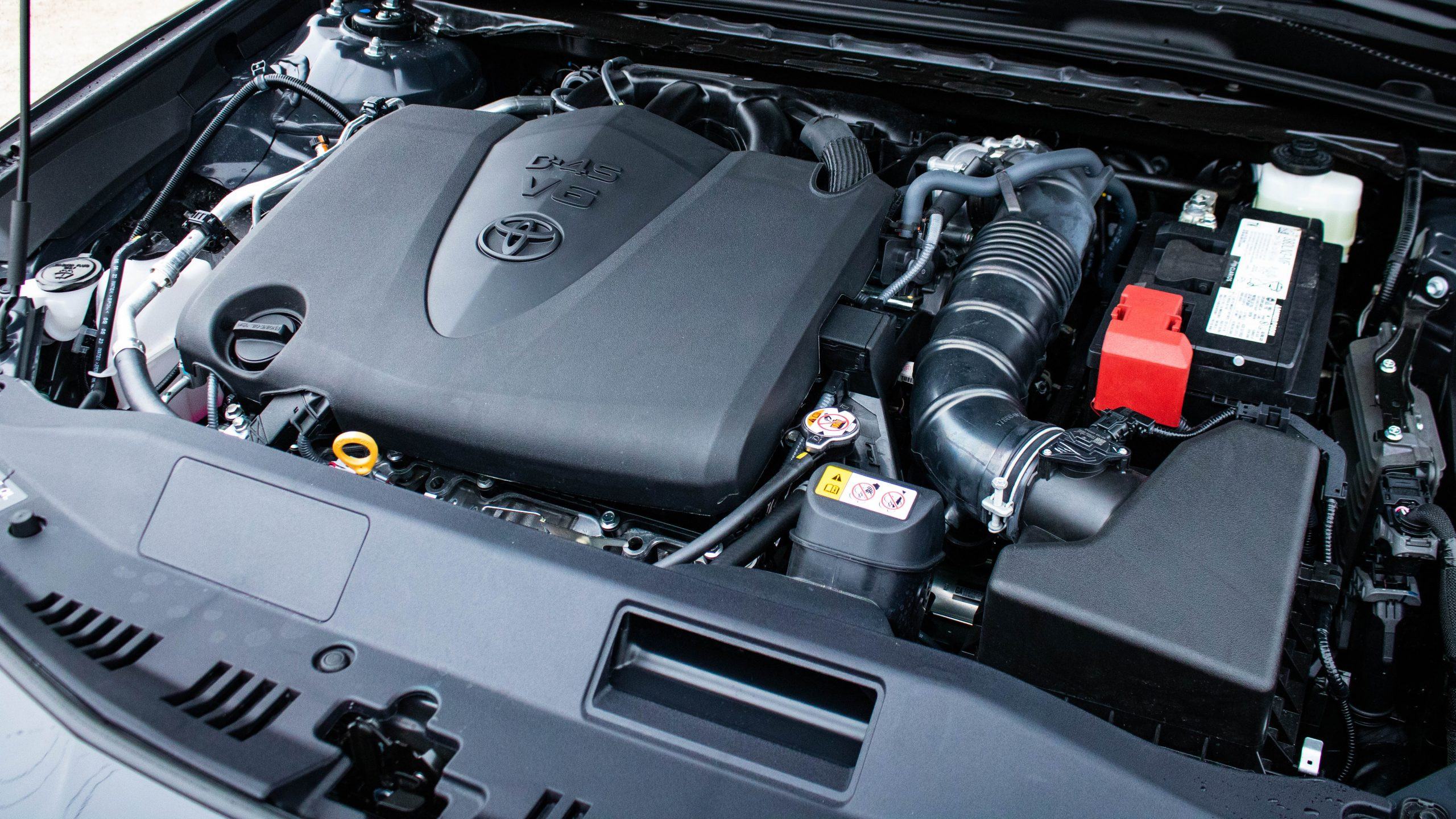 Engine bay of the 2024 Toyota Camry TRD V6, showcasing the 3.5-liter V6 engine and engine components.