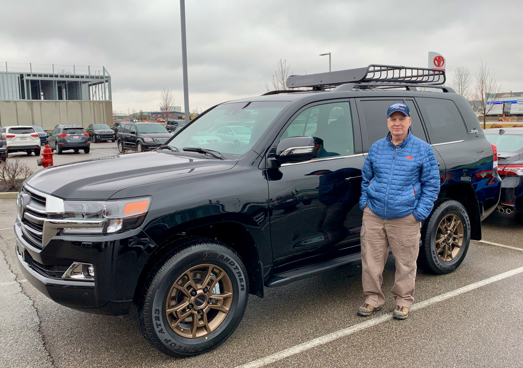 Side profile of the 2021 Toyota Land Cruiser Heritage Edition in a driveway, emphasizing its stock suspension and wheels.
