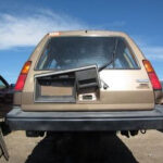 alt text: A side view of a rusty Toyota Tercel 4WD wagon in a junkyard.