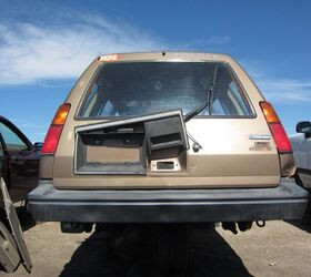 alt text: A side view of a rusty Toyota Tercel 4WD wagon in a junkyard.