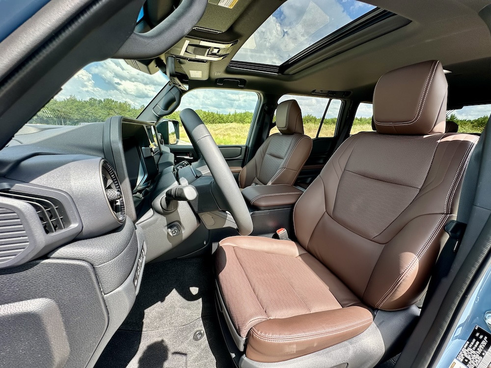 Interior shot of the Land Cruiser Premium emphasizing the leather seats, physical climate controls, and overall comfortable and functional cabin space.