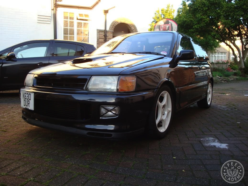 Rear view of the Toyota Starlet GT EP82 highlighting its sporty hatchback design and Enkei wheels.