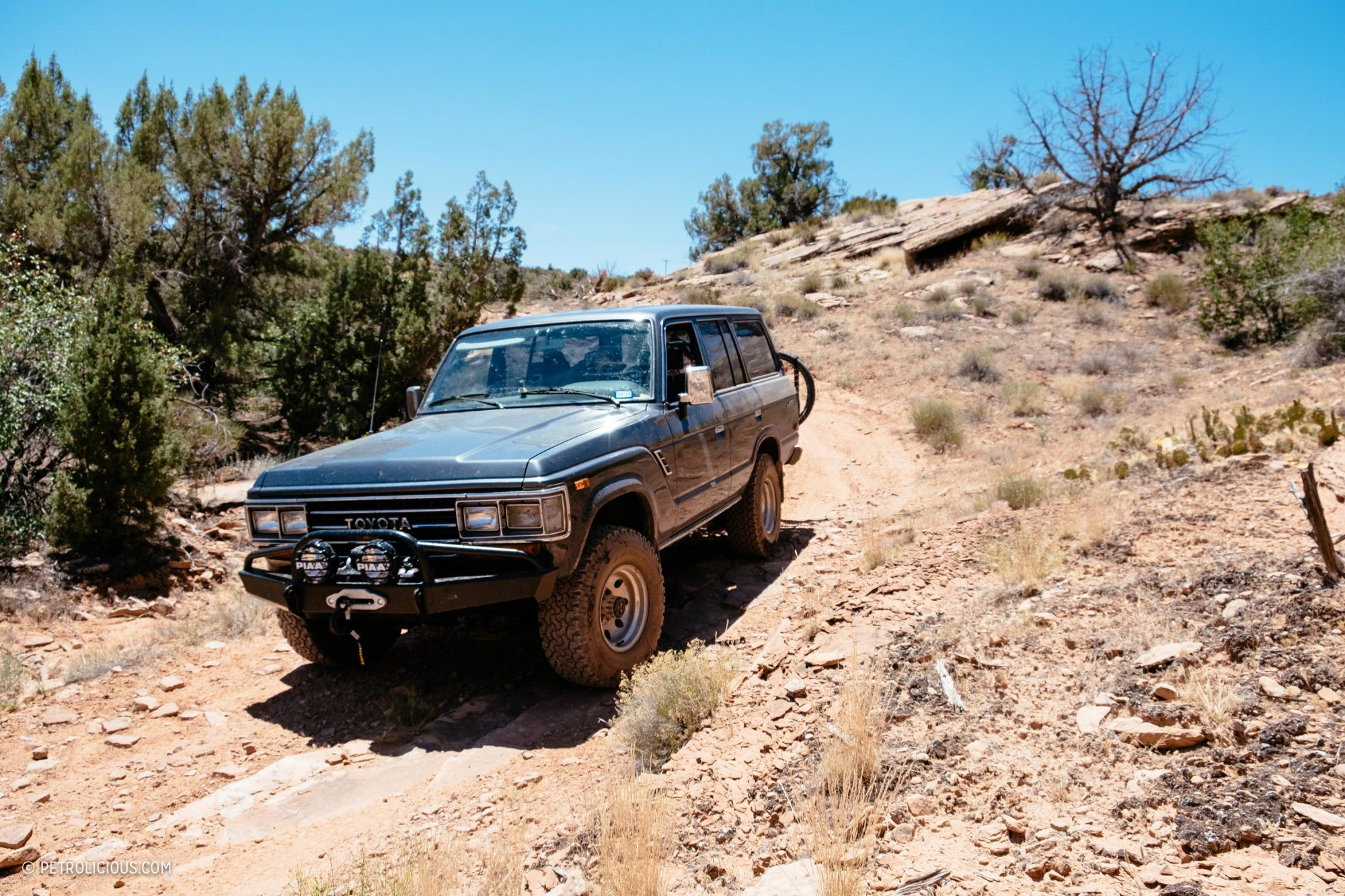 An old Toyota Land Cruiser parked on a quiet street in a small desert town, highlighting its vintage charm