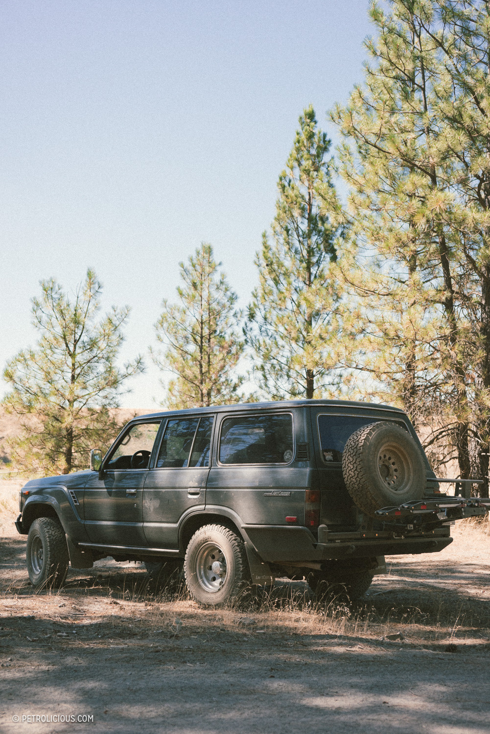 Side mirror and window of a classic Toyota Land Cruiser reflecting the surrounding landscape