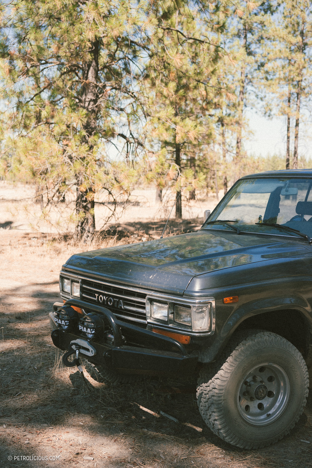 Steering wheel and dashboard of an old Toyota Land Cruiser emphasizing its vintage appeal