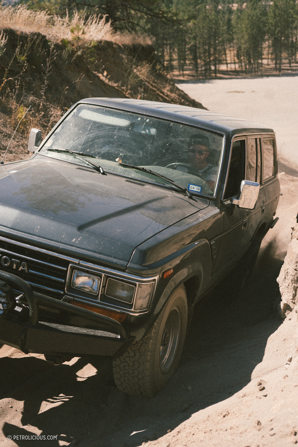 Toyota Land Cruiser parked on a mountain trail overlooking a valley