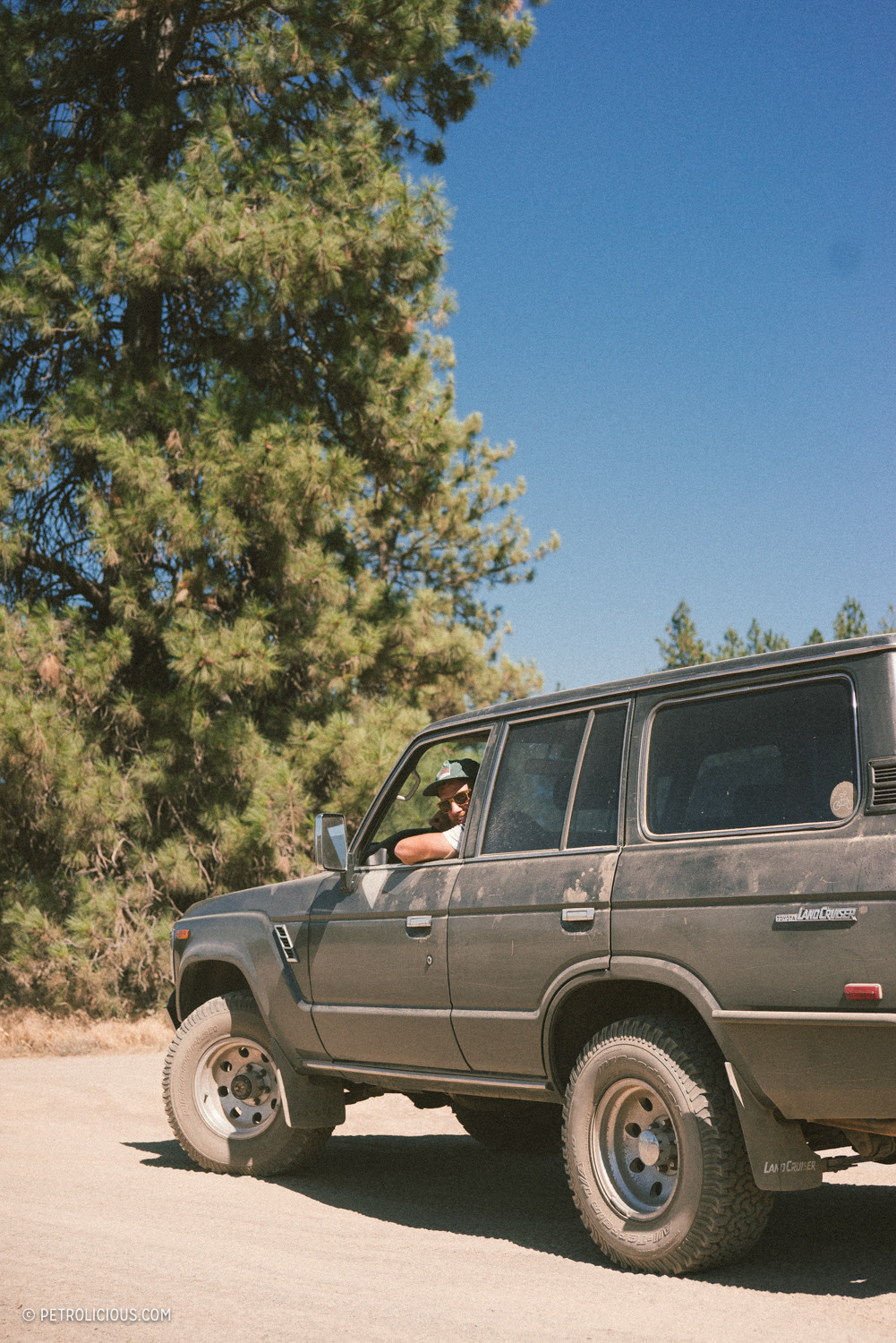 Toyota Land Cruiser navigating a dirt trail through a mountainous landscape