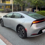 A silver toyota Prius prime seen from behind