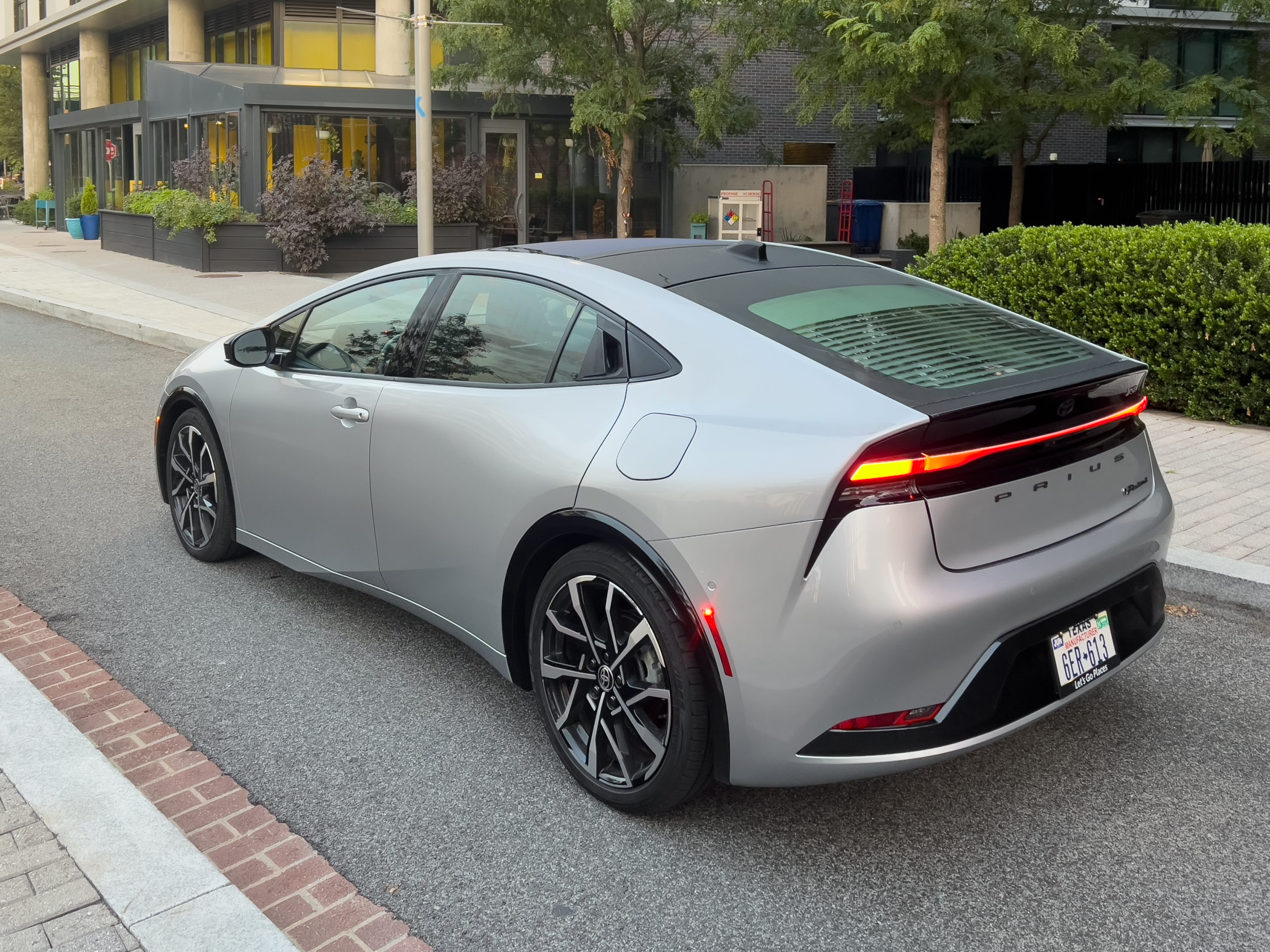 A silver toyota Prius prime seen from behind