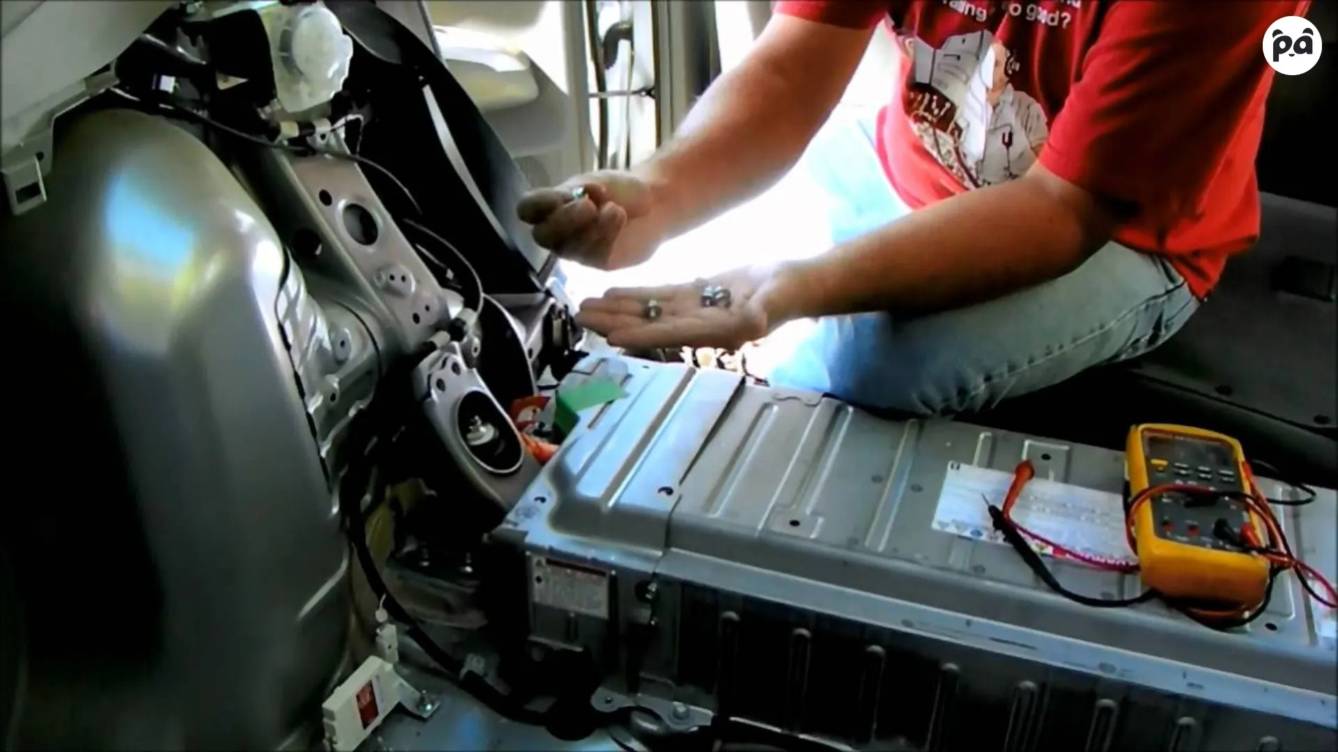 A mechanic working on a Toyota Prius hybrid battery, showcasing the intricate components involved.