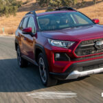 a red used Toyota RAV4 SUV driving down the road toward the lens of the camera