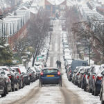 A car driving in snow down a hill