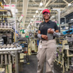 Robots assemble panels around the vehicle's frame at Toyota factory