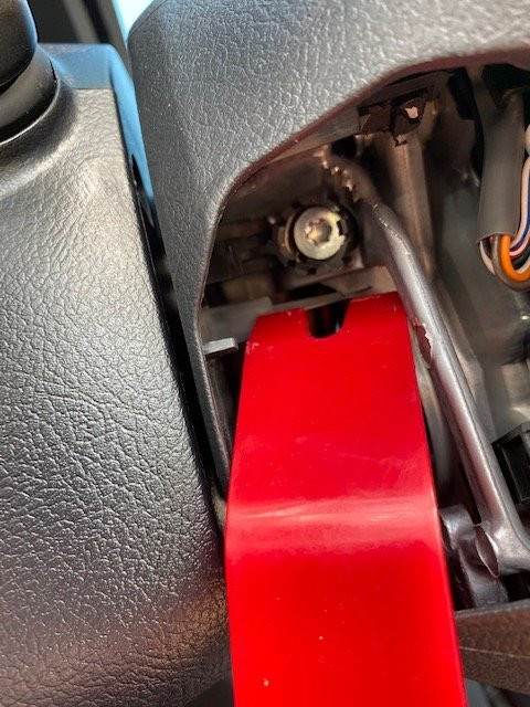 Removing left steering wheel cap to access airbag screws