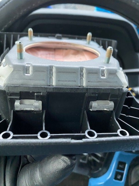 Loosening metal prongs to remove the airbag