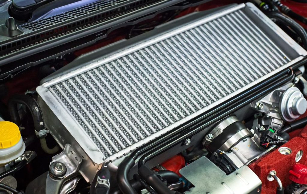 A close-up of a car radiator showing signs of wear and corrosion.