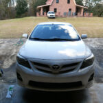 Working on the front bumper of 2013 Toyota Corolla, ensuring proper maintenance and longevity.