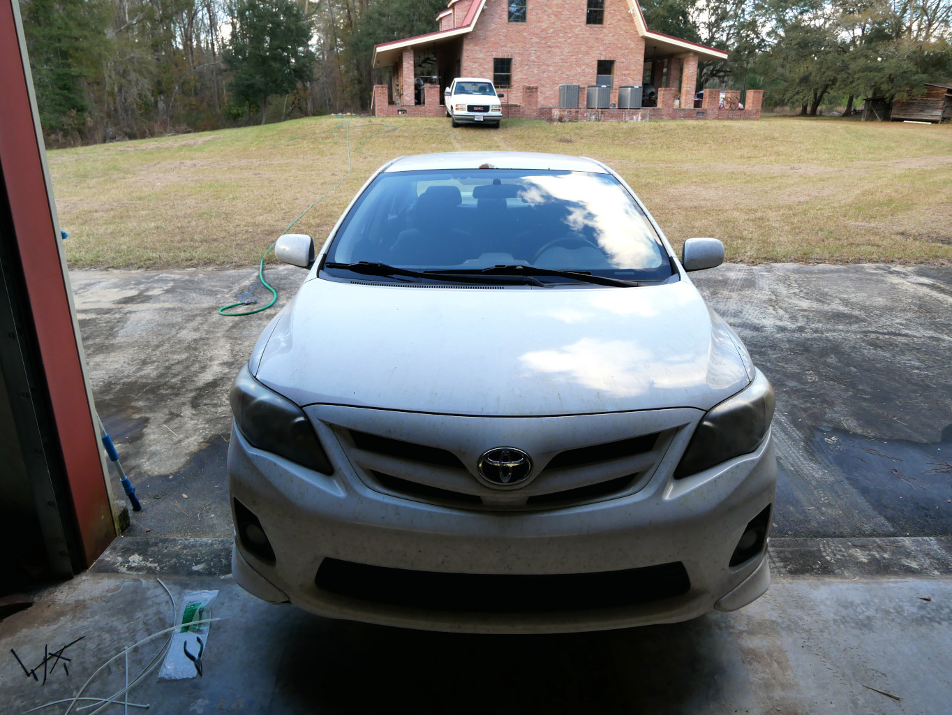 Working on the front bumper of 2013 Toyota Corolla, ensuring proper maintenance and longevity.